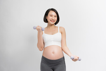 Pregnant woman lifting dumbbell on white background