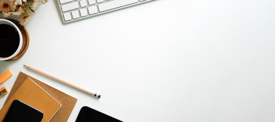 Top view office stuff with notepad, laptop and coffee cup mouse notepad shot.blank screen mobile phone and supplies on white desk workspace and copy space.