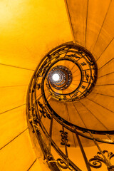 A view up a spiral staircase in Budapest in the summertime