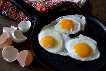on a black background. Fried three eggs.
