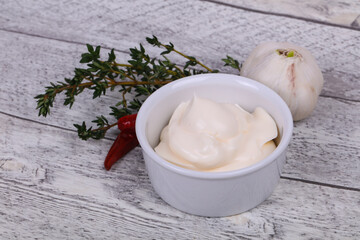 Mayonnaise sauce in the white bowl served thyme and garlic
