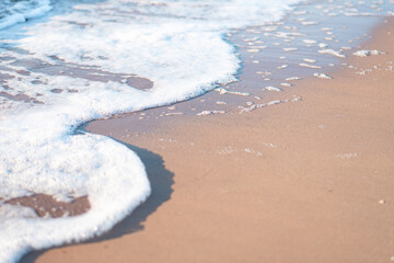foamy wave running onto a sandy beach