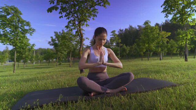 Young woman yoga outdoors keep calm and meditates while practicing yoga to explore the inner peace.