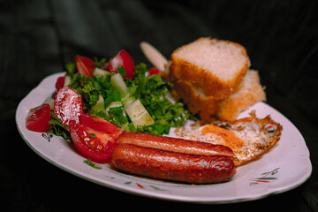 Grilled sausages on a plate on wooden background