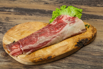 Raw beef bacon over wooden board