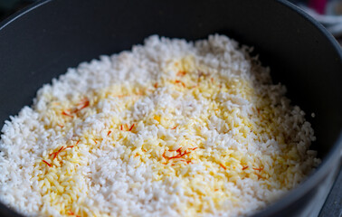 Rice and saffron in a cauldron for cooking pilaf