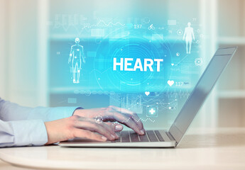 Obraz premium Doctor working a health check with HEART inscription, recording medical test results