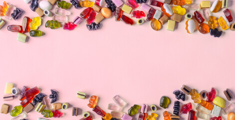 Fototapeta na wymiar Colorful candy on pink background. Chewing sweets on light table. Top view, flat lay, copy space, banner
