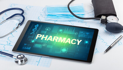 Tablet pc and medical stuff with PHARMACY inscription, prevention concept
