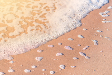 white foam from the sea wave remained in the sand