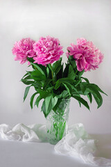 bouquet of three pink peonies in the glass vase