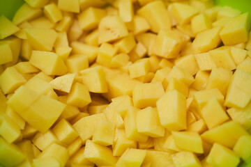 Fresh potatoes in pieces in green utensils. Close-up