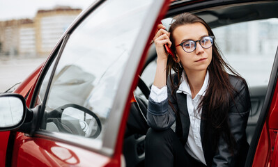 The girl in the car. A woman in a parking lot sits in a auto.