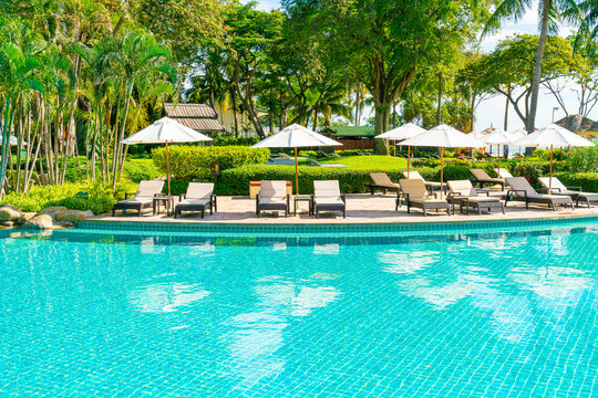 Beautiful umbrella and chair around swimming pool in hotel and resort