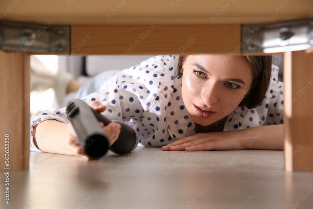 Wall mural Young woman using vacuum cleaner at home