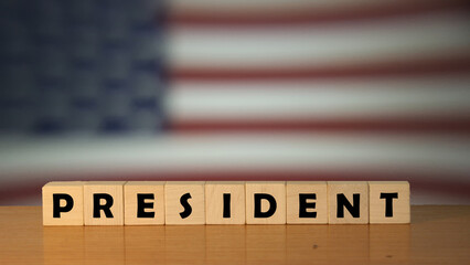 PRESIDENT USA message word on a wooden desk on cube blocks with a USA flag background