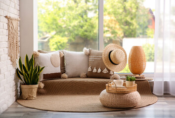 Comfortable place for rest with cushions near window indoors - obrazy, fototapety, plakaty