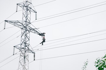Male electricians make repairs on the electric tower. Power line against the sky.June 6, 2020 Saint-Petersburg, Russia