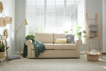 Stylish beige sofa in modern living room interior