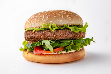 Tasty hearty vegetarian hamburger with falafel and herbs for take away or food delivery isolated on a white background.