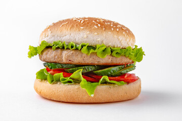 Tasty hearty hamburger with vegetables, cheese and herbs for take away or food delivery isolated on a white background.