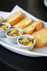 Baked baby clams with butter, onions, parsley served with garlic and butter french bread.