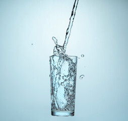 Water Pouring Into a Glass on a blue gradient