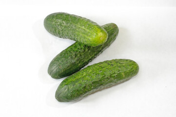 Three green cucumbers on a white background. Cucumbers on a white background. 3 cucumbers.