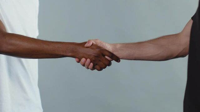 Hands white and black men shake hands stop racism all people are equal togetherness symbol tolerance multiracial peace interracial friendship anti-racism slow motion