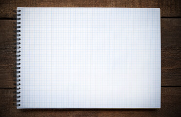 squared notebook sheet on wooden background