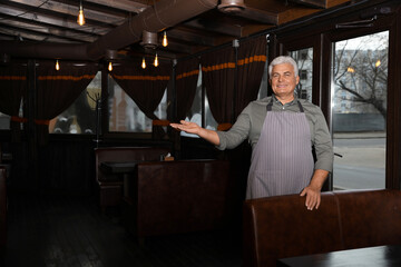 Fototapeta na wymiar Senior male business owner in his restaurant