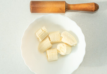 Pusher and chopped banana in the bowl. Process of cooking oatmeal porridge with banana and fresh blueberries. Healthy breakfast every morning. Healthy lifestyle and eating, cooking at home  concepts.