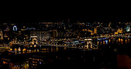 Fototapeta na wymiar The view from the Fisherman's Bastion towards the Chain Bridge eastward along the River Danube in Budapest at night during the summertime