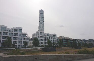 Naklejka premium Scandinavian landscape. Modern low-rise residential quarter with a skyscraper in the city of Malmo. And cloudy sky