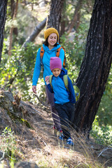 A woman walks with her son through the forest.