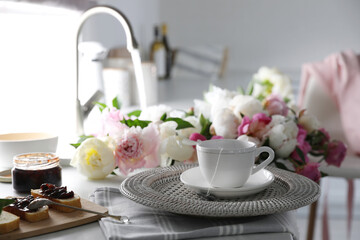 Beautiful peonies and breakfast on kitchen counter