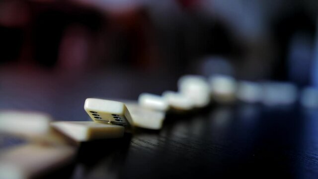 Domino slowly falling on a wooden table