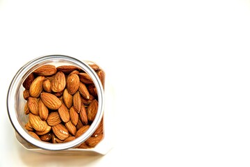 almond seeds in glass jar on white background