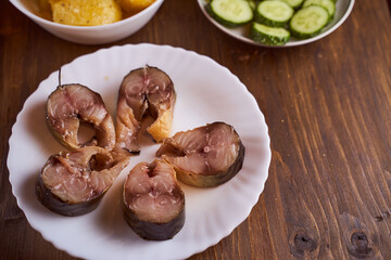 pieces of sardine in a plate on a brown table