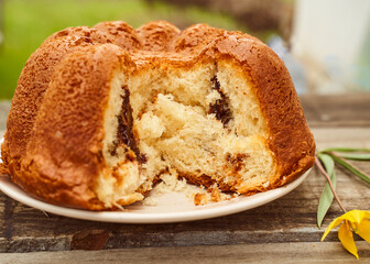 Homemade cupcake with chocolate filling inside on a wooden table with a Yellow Woodland tulips, Wild tulips on a wooden background. Close-up.