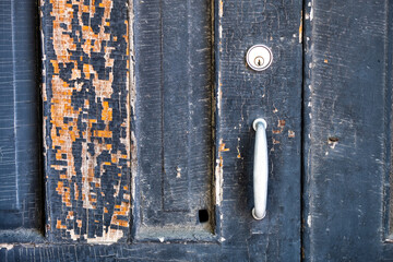 Peeling paint on old weathered door.