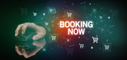 hand holding wireless peripheral with BOOKING NOW inscription, online shopping concept