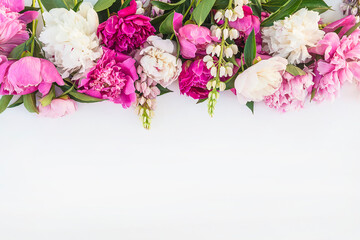 Beautiful floral frame of bunch of purple, pink, and white peonies on white background. Space for text, flat lay