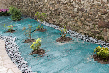 flowerbed with shrubs, weed protection green tarpaulin, © Veronika