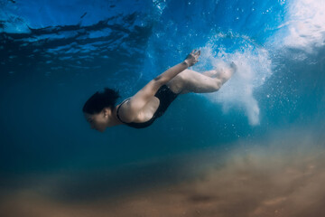 Obraz na płótnie Canvas Woman dive without surfboard under wave. Underwater duck dive under wave and sandy bottom