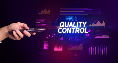 hand holding wireless peripheral with QUALITY CONTROL inscription, cyber business concept