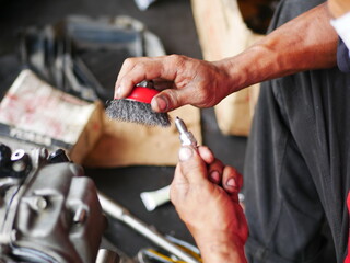 Mechanic working on motorcycle engine in workshop. 