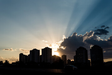 Silhouette cityscape with sunlight in sky
