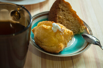 Custard cookies and  tea, golden eclair filled with whipped cream