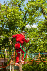 Girl climbing in high rope course enjoying the adventure